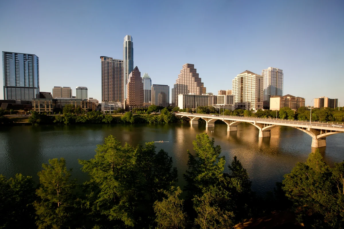 Austin skyline and Congress Avenue Bridge reflected in Lady Bird Lake at sunset